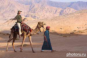 Иордания, Wadi Rum. Фототур с фотомоделью. Съемки в пустыне. Девушка на верблюде на фоне гор в пустыне Вади Рам. Фото Юрия Афанасьева.
